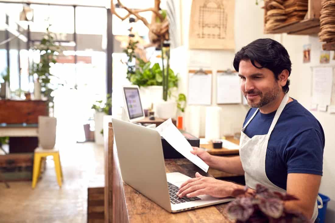 Male botanical store owner calculates ending inventory