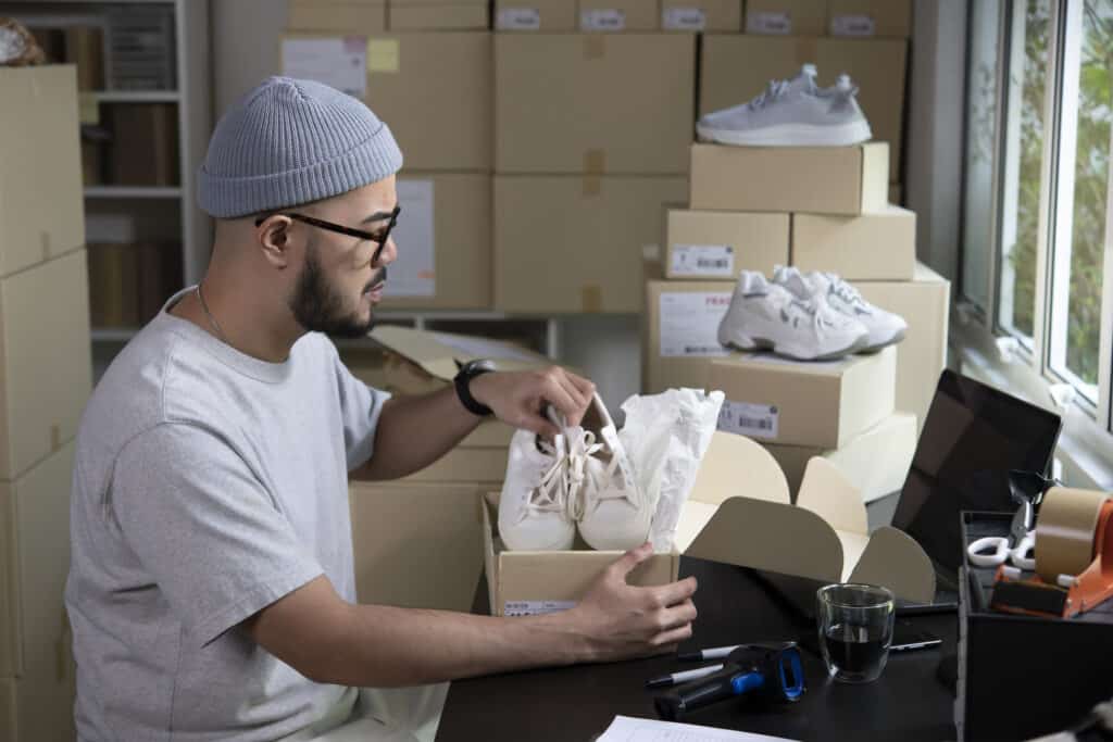 Male entrepreneur packaging box for delivery in store warehouse